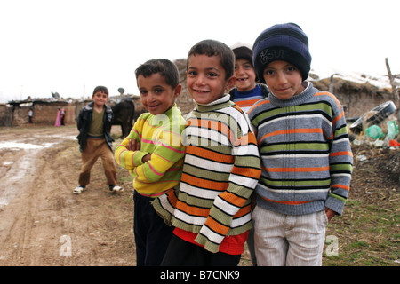 Les enfants curieux en face de huttes de boue dans un petit village près de Amedi kurde dans le nord de l'Irak près de la frontière turque, Ira Banque D'Images