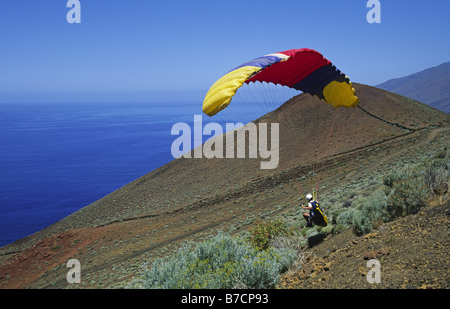 Homme avec un planeur sur la côte sud prêt à aller, Canaries, El Hierro Banque D'Images
