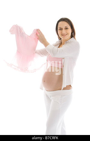 Pregnant woman holding up a pink tutu smiling Banque D'Images