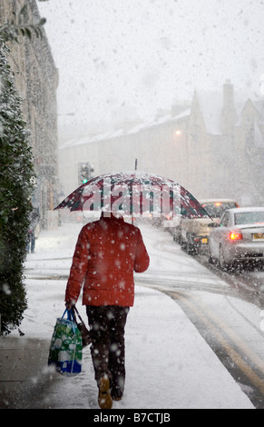 Femme marche dans les fortes chutes de neige La neige sur un trottoir Banque D'Images