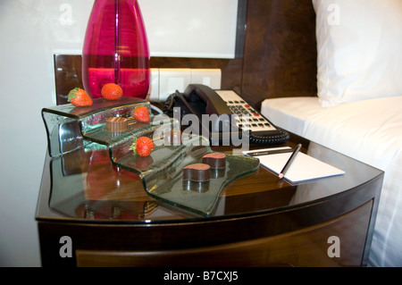 Chambre d'hôtel table de chevet avec des chocolats Banque D'Images