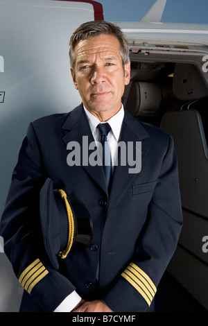 Un pilote debout devant la porte d'un avion Banque D'Images