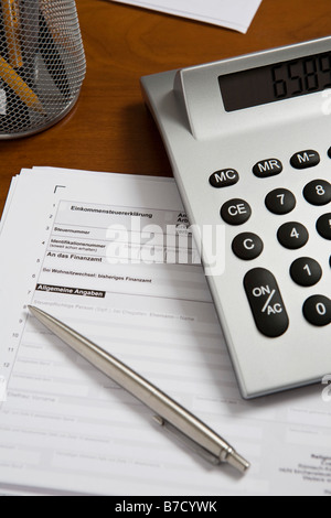 Une calculatrice et stylo en haut d'une déclaration d'impôt Banque D'Images