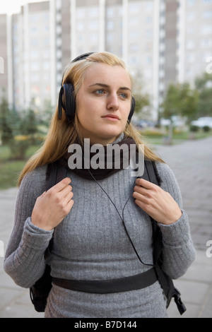 Une jeune fille portant des écouteurs en attente Banque D'Images