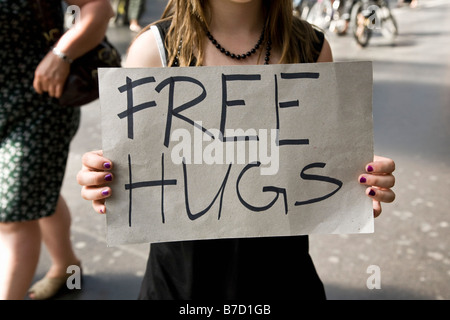 Une jeune femme tenant une pancarte disant Free Hugs Banque D'Images