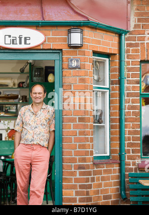 Homme debout en face d'un café Banque D'Images