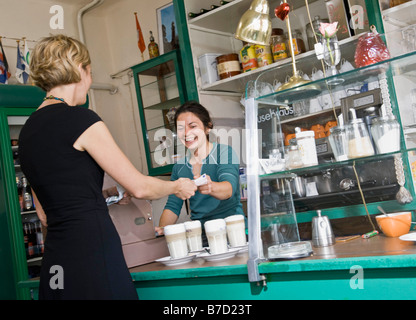 Barista femelle aider un client femelle Banque D'Images