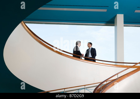 Deux hommes debout sur un balcon et de parler Banque D'Images