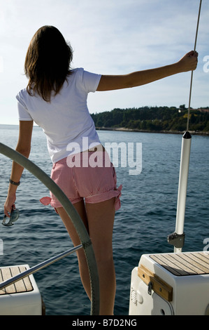 Vue arrière d'une femme debout sur un yacht Banque D'Images