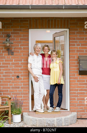 Famille à la porte d'une maison Banque D'Images