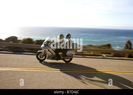 Couple sur une moto qui circulent sur l'autoroute Rt. 1 entre San Simeon & Gorda, California, USA Banque D'Images