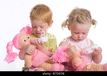 Deux petites filles nourrissent leurs dolls Banque D'Images