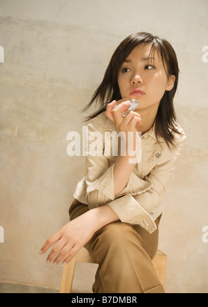 Young woman sitting on chair Banque D'Images