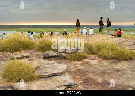 Les touristes de prendre dans un coucher de soleil avec vue sur la plaine d'Ubirr Nardab dans le Kakadu National Park Banque D'Images