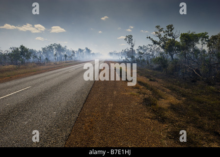 La fumée d'un feu de broussailles contrôlée couvre la route dans le Kakadu National Park Banque D'Images