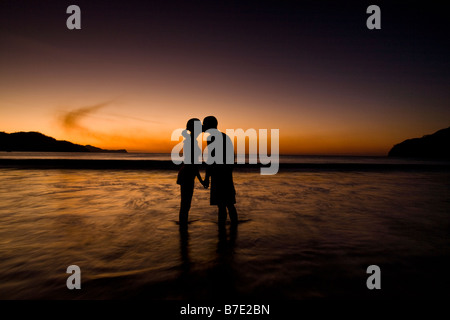 Silhouette de couple sur la plage pendant le coucher du soleil à Playas del Coco, Costa Rica. Banque D'Images