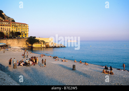 La plage de Nice dans la soirée, les gens de manger sur la plage et regarder le coucher du soleil Banque D'Images