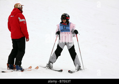 Enfant apprenant à skier; jeune fille écoutant son instructeur de ski pendant une leçon de ski, Avoriaz, France Banque D'Images