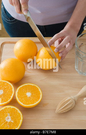 Woman cutting oranges Banque D'Images