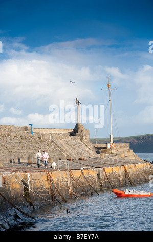 Personnes marchant à New Quay harbour Ceredigion Pays de Galles UK, sur une après-midi d'hiver Janvier lumineux Banque D'Images