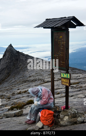 Tired woman désespère d'atteindre le sommet du Mont Kinabalu à Bornéo, Malaisie Banque D'Images