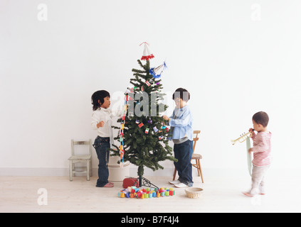 Enfants decorating Christmas Tree Banque D'Images