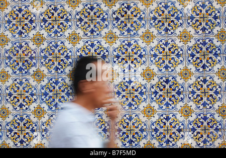 Man Walking Cours des tuiles de couleurs dans la rue, Macau Banque D'Images