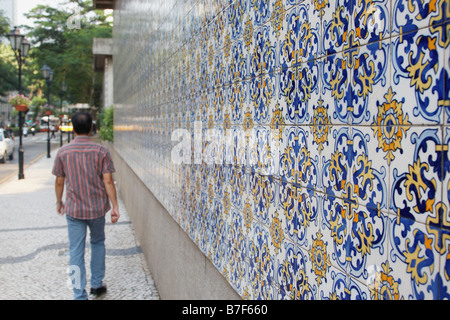 Man Walking Cours des tuiles de couleurs dans la rue, Macau Banque D'Images