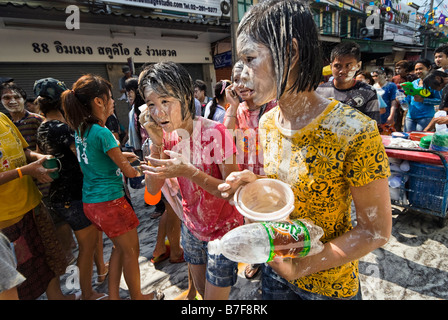 Jeune femme recouverte d'un mélange de farine et de l'eau composant sur téléphone mobile pendant Songkran festival - Bangkok Thaïlande Banglamphu Banque D'Images