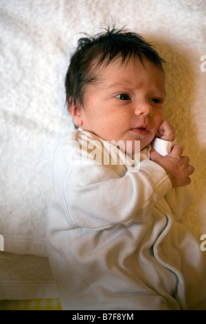 Un nouveau-né dans un sleepsuit blanc Banque D'Images