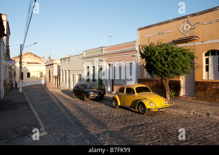 Une scène de rue avec une Vw Bug jaune Banque D'Images