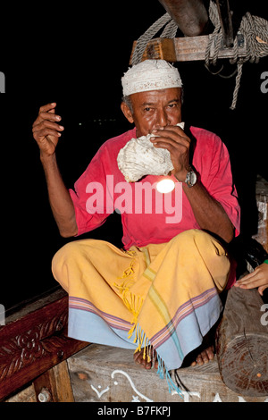 Arab man blowing conque soir balade en bateau de dhow Jahazi Mombasa Kenya Banque D'Images