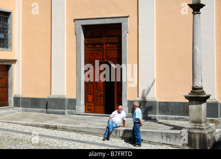Deux hommes discuter en face de l'église paroissiale de San Gottardo, Intragna, Centovalli, Tessin, Suisse Banque D'Images