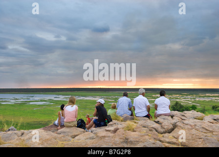 Les touristes de prendre dans un coucher de soleil avec vue sur la plaine d'Ubirr Nardab dans le Kakadu National Park Banque D'Images