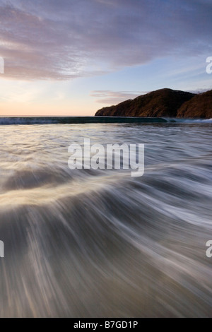 Se précipitant sur les vagues de la côte volcanique de Playas del Coco, Costa Rica. Banque D'Images
