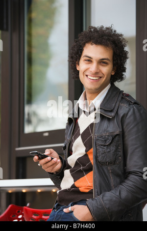 Middle Eastern man text messaging on cell phone Banque D'Images