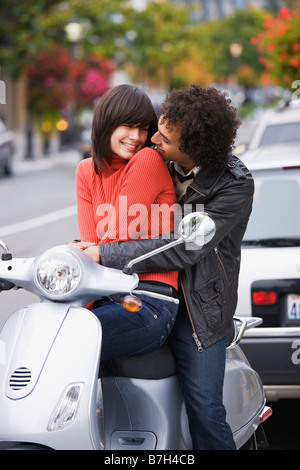 Couple sitting on scooter Banque D'Images