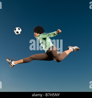 African woman playing soccer in mid-air Banque D'Images