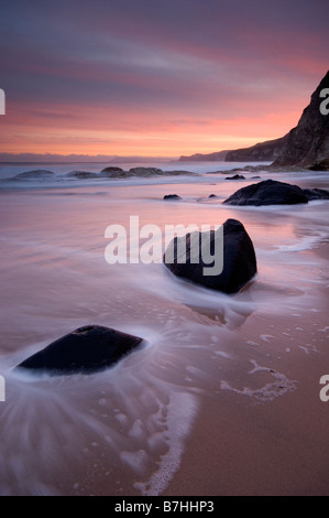 Paysage pittoresque image de Whiterocks beach au lever du soleil avec le mouvement dans les vagues, près de Portrush le comté d'Antrim en Irlande du Nord Banque D'Images