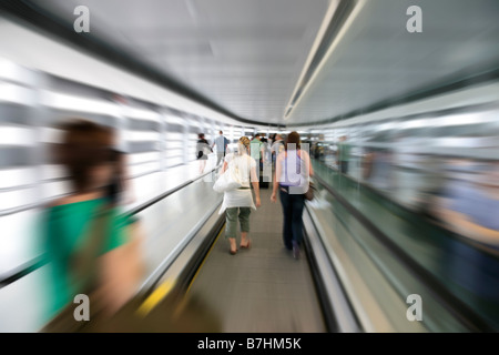 Voyageurs sur trottoir roulant à l'aéroport Banque D'Images