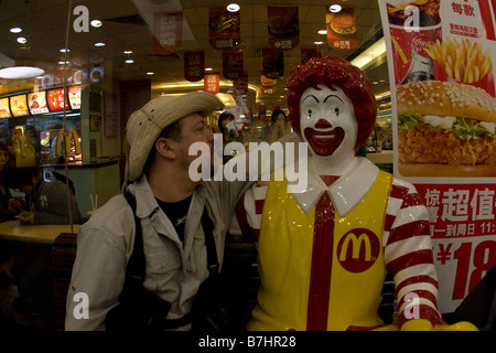 Un homme assis avec Ronald McDonlad fumée soufflage Banque D'Images
