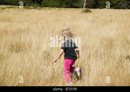 Sidney Spit Marine Park, BC, Canada. 5 ans jouant dans un champ d'herbe. Banque D'Images