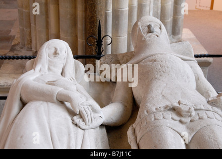 14e siècle en pierre des effigies de chevalier en armure tenant la main avec son épouse à guimpe, voile et robe, la cathédrale de Chichester Banque D'Images