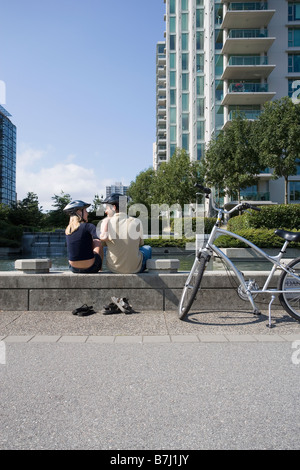 Jeune couple reste à partir de la bicyclette à la fontaine, Vancouver, Colombie-Britannique Banque D'Images