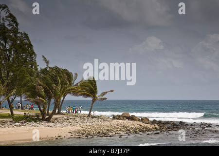 Les badauds regarder comme des vagues s'écraser sur le rivage de l'île Pigeon, St Lucie, West Indies. Banque D'Images