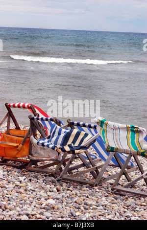 Chaises longues battues sur une plage vide peut jour vacances de banque Dorset UK Banque D'Images