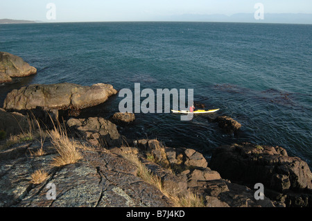 Kayak homme off côte rocheuse, Sheringham Point Lighthouse, Sooke, BC, Canada Banque D'Images