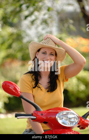 Jeune femme sur vespa rouge avec chapeau de cowboy, Regina, Saskatchewan Banque D'Images