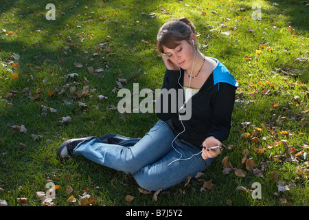 Jeune femme à l'écoute de l'Ipod à l'extérieur, Brantford, Ontario Banque D'Images