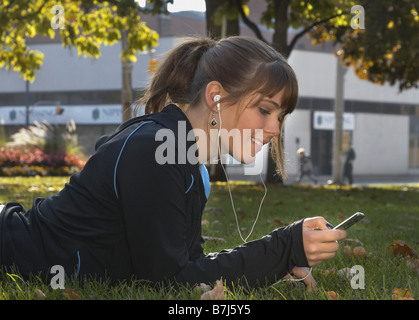 Jeune femme à l'écoute de l'Ipod à l'extérieur, Brantford, Ontario Banque D'Images